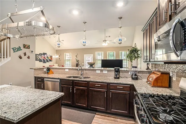 a kitchen with stainless steel appliances granite countertop a sink stove and refrigerator