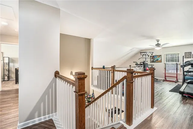 a view of a hallway with wooden floor and stairs