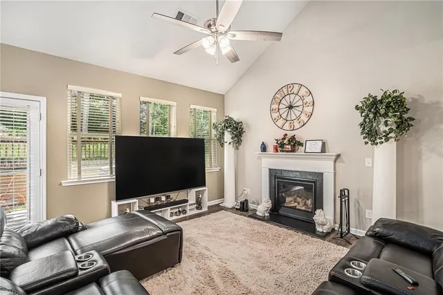 a living room with furniture a flat screen tv and a fireplace