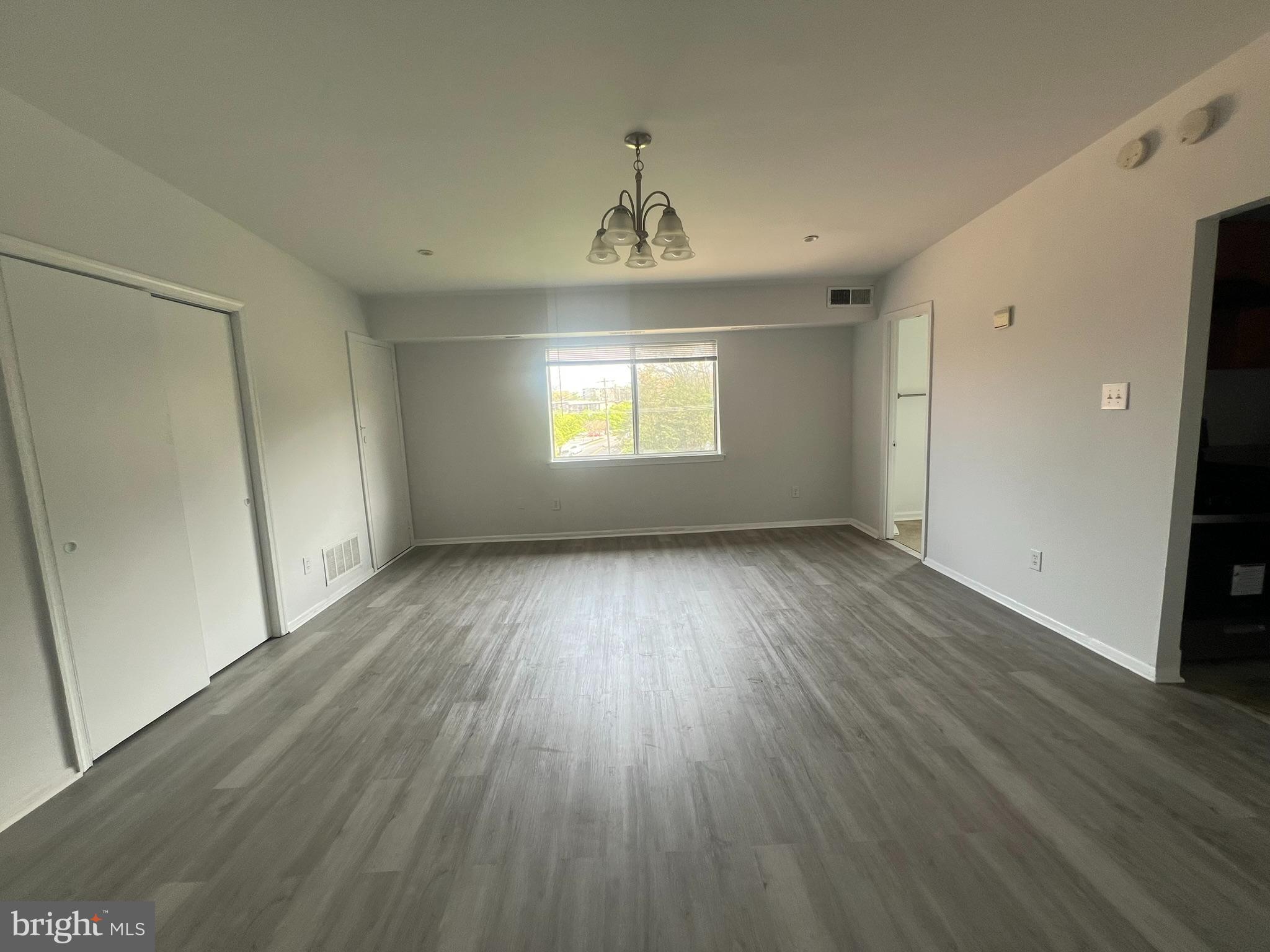 7521 Riverdale Road, Unit 1979 New Carrollton, MD 20784 - Photo 2 of 8 an empty room with wooden floor and windows