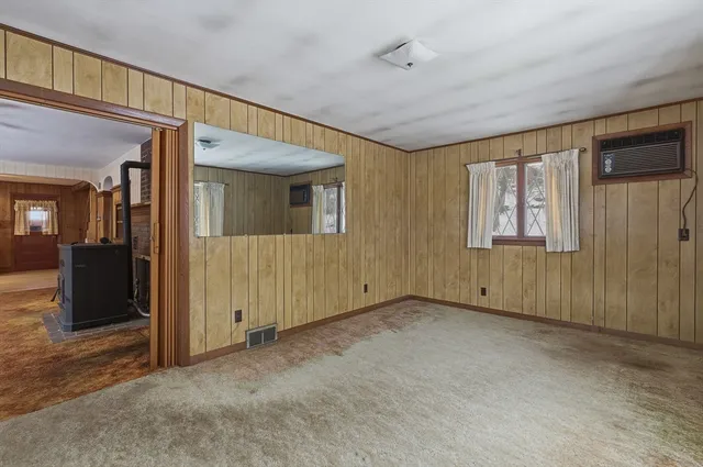 an empty room with windows closet and chandelier fan