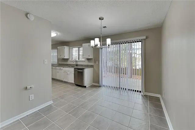 a kitchen with granite countertop a stove a sink and a refrigerator