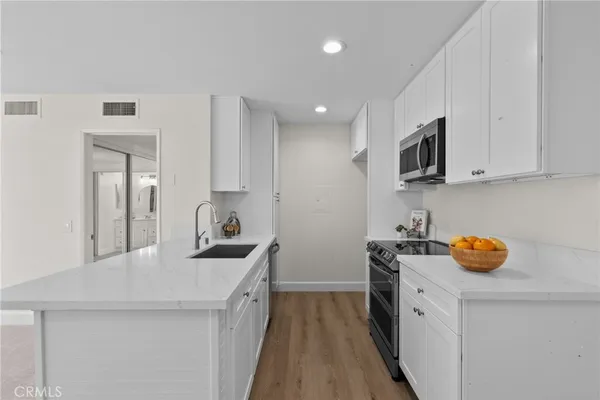 a kitchen with a sink a stove and cabinets
