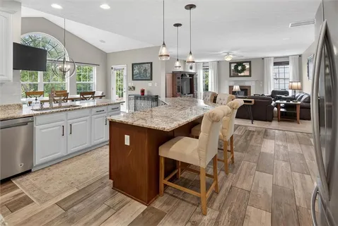 a kitchen with kitchen island granite countertop a sink stove and refrigerator