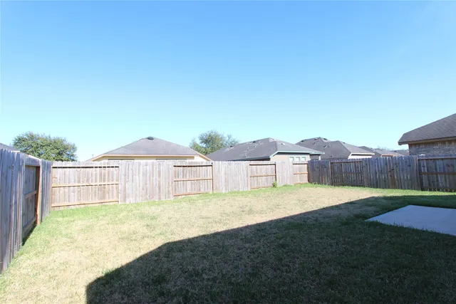 a view of a house with a yard and wooden fence