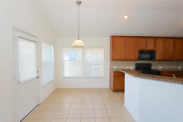 a kitchen with granite countertop a sink a counter space appliances and cabinets