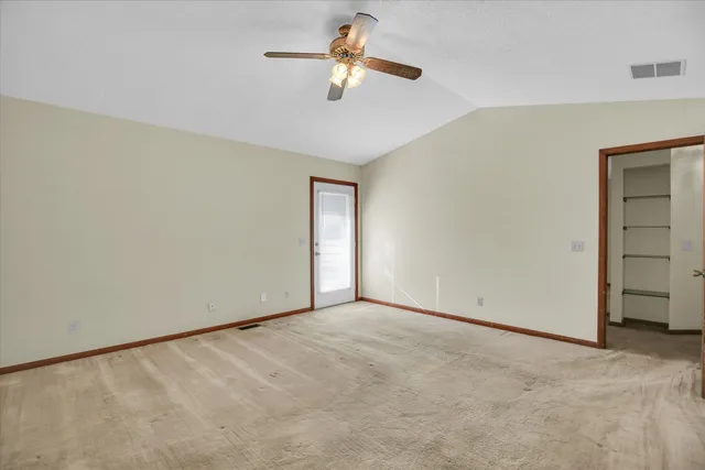 a view of a room with ceiling fan and window