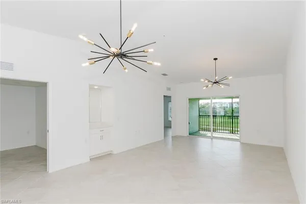an empty room with windows and ceiling fan