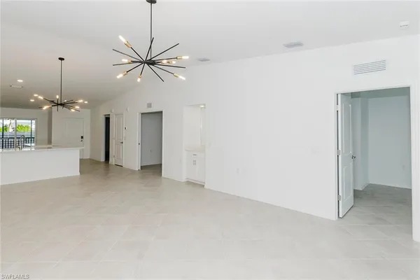 a view of a room with a chandelier fan and windows