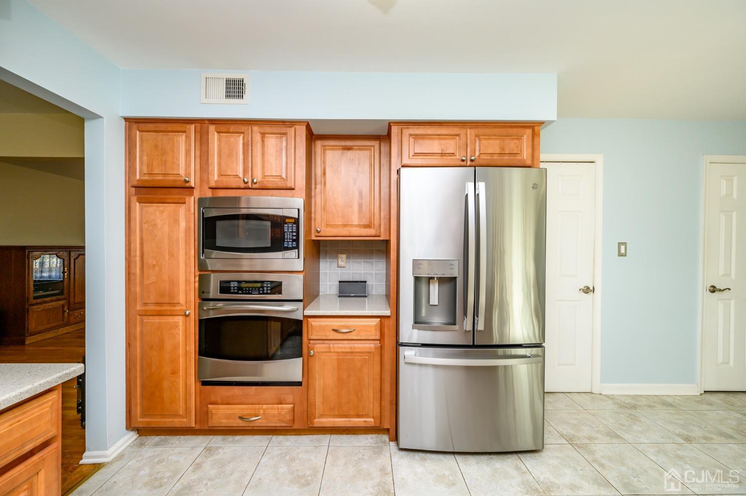 40 Fairfield Road Princeton, NJ 08540 - Photo 16 of 46 a kitchen with stainless steel appliances wooden cabinets and a refrigerator