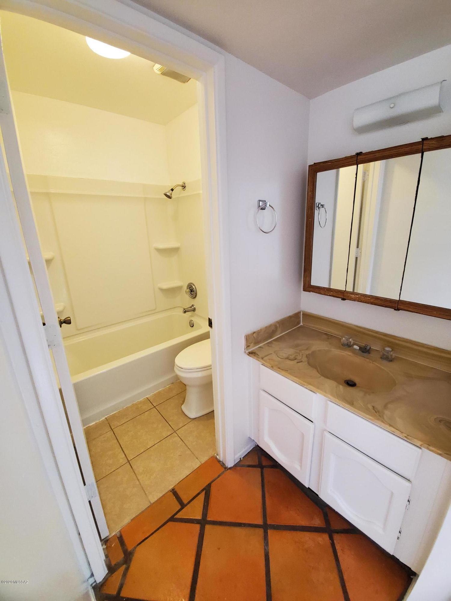 1057 East Halcyon Road Tucson, AZ 85719 - Photo 5 of 10 a bathroom with a granite countertop sink toilet and shower