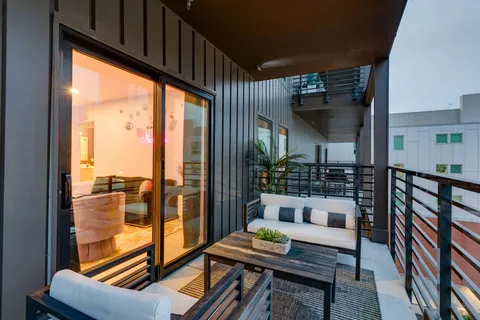 a living room with furniture a potted plant and a projector