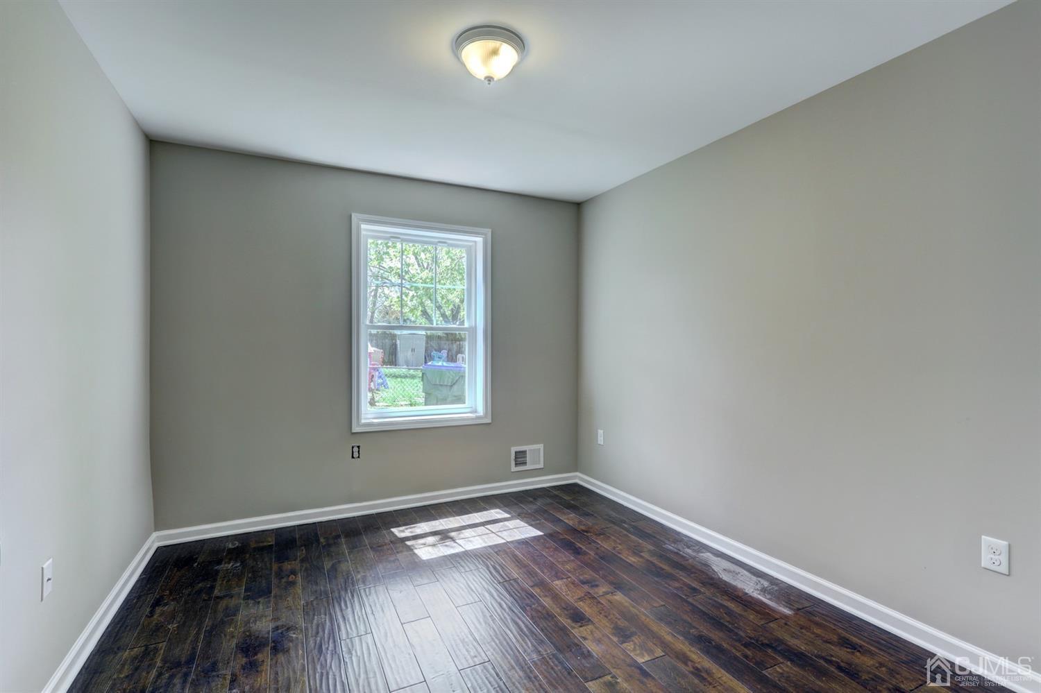 14 Richmond Road Edison, NJ 08817 - Photo 10 of 17 an empty room with wooden floor and windows