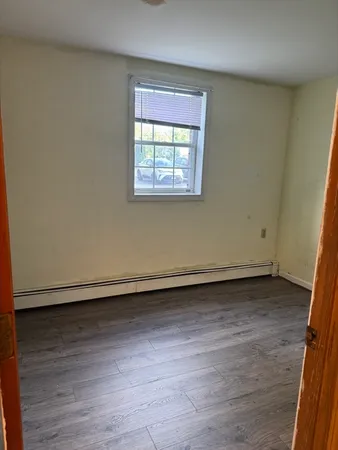 a view of a room with wooden floor and window