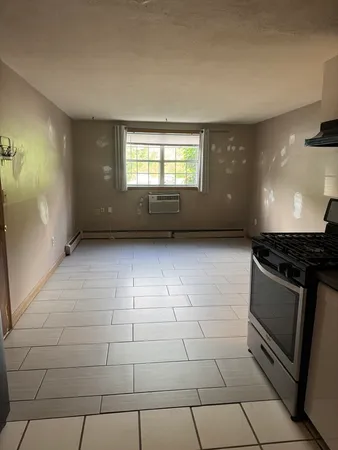 a view of an empty room with a fireplace and a window
