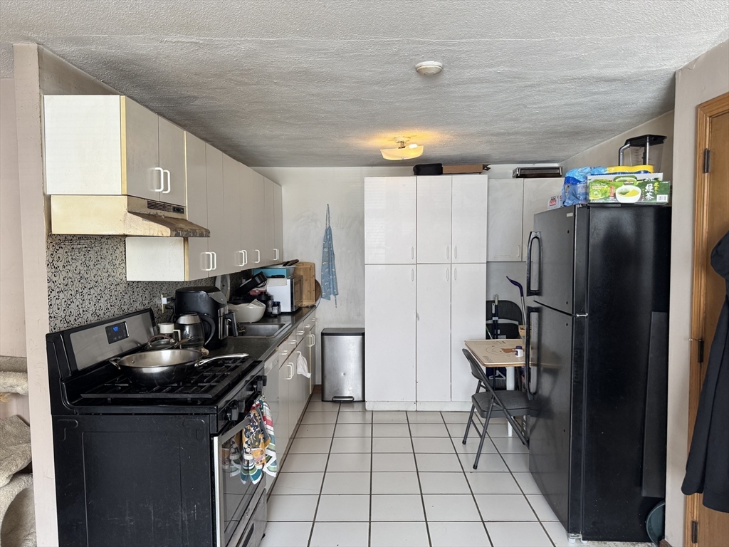 428 Great Road, Unit 6 Acton, MA 01720 - Photo 7 of 9 a kitchen with granite countertop a sink a counter and refrigerator