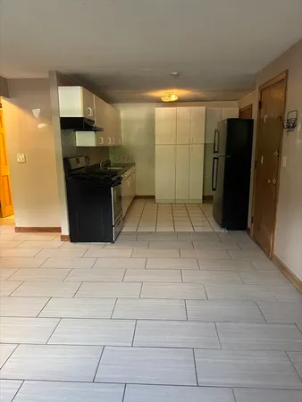 a kitchen with granite countertop a refrigerator and a stove top oven