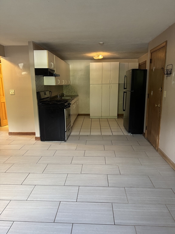 428 Great Road, Unit 6 Acton, MA 01720 - Photo 8 of 9 a kitchen with granite countertop a refrigerator and a stove top oven