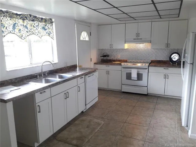 a kitchen with a sink stove and cabinets