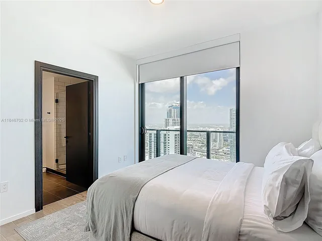 a bedroom with a large bed and a large window