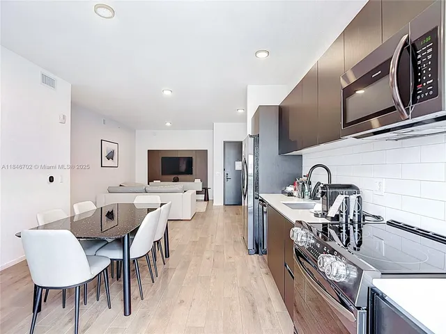 a large kitchen with a table and chairs