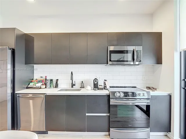 a kitchen with a sink cabinets and stainless steel appliances