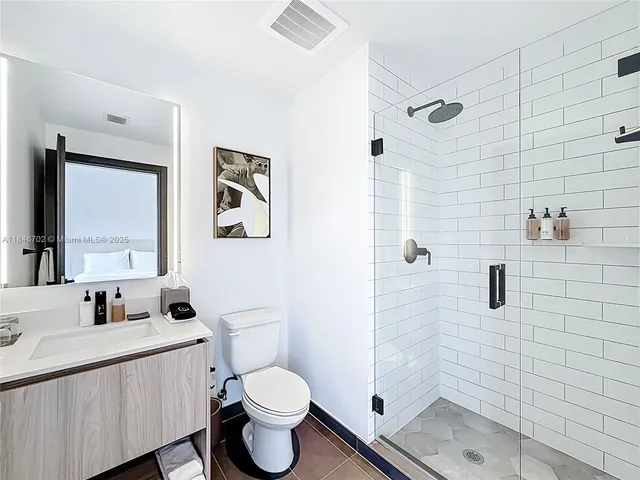 a bathroom with a toilet sink a shower and mirror