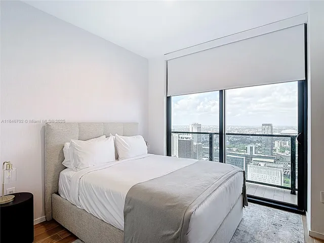 a bedroom with a large bed and a large window