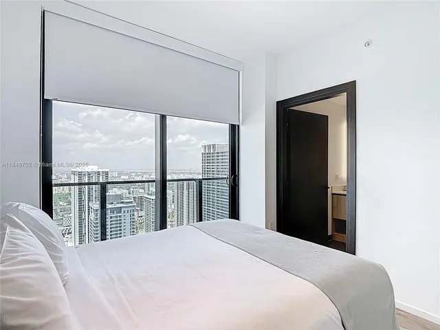 a bedroom with a large bed and a large window