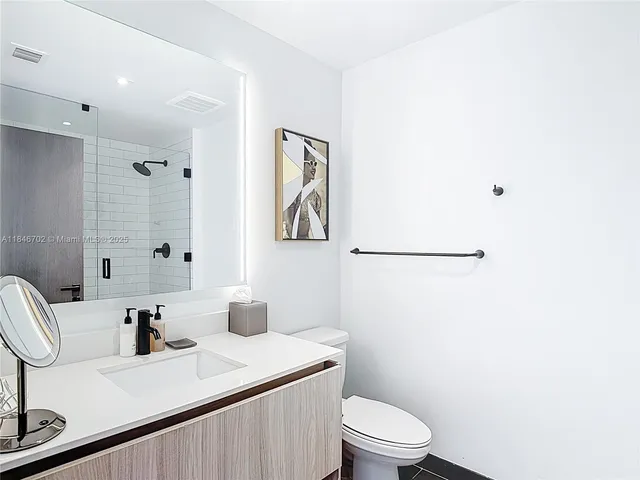 a bathroom with a sink a toilet and mirror