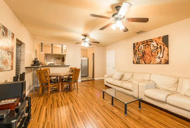 a living room with furniture and wooden floor
