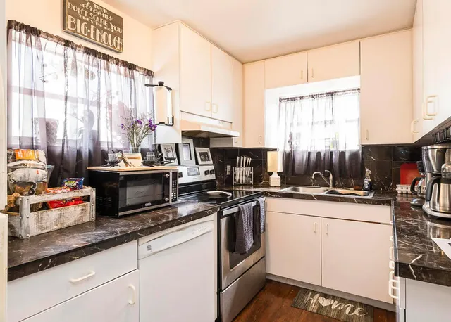 a kitchen with stainless steel appliances a sink a stove and a window