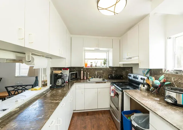 a kitchen with a sink appliances cabinets and a counter top space