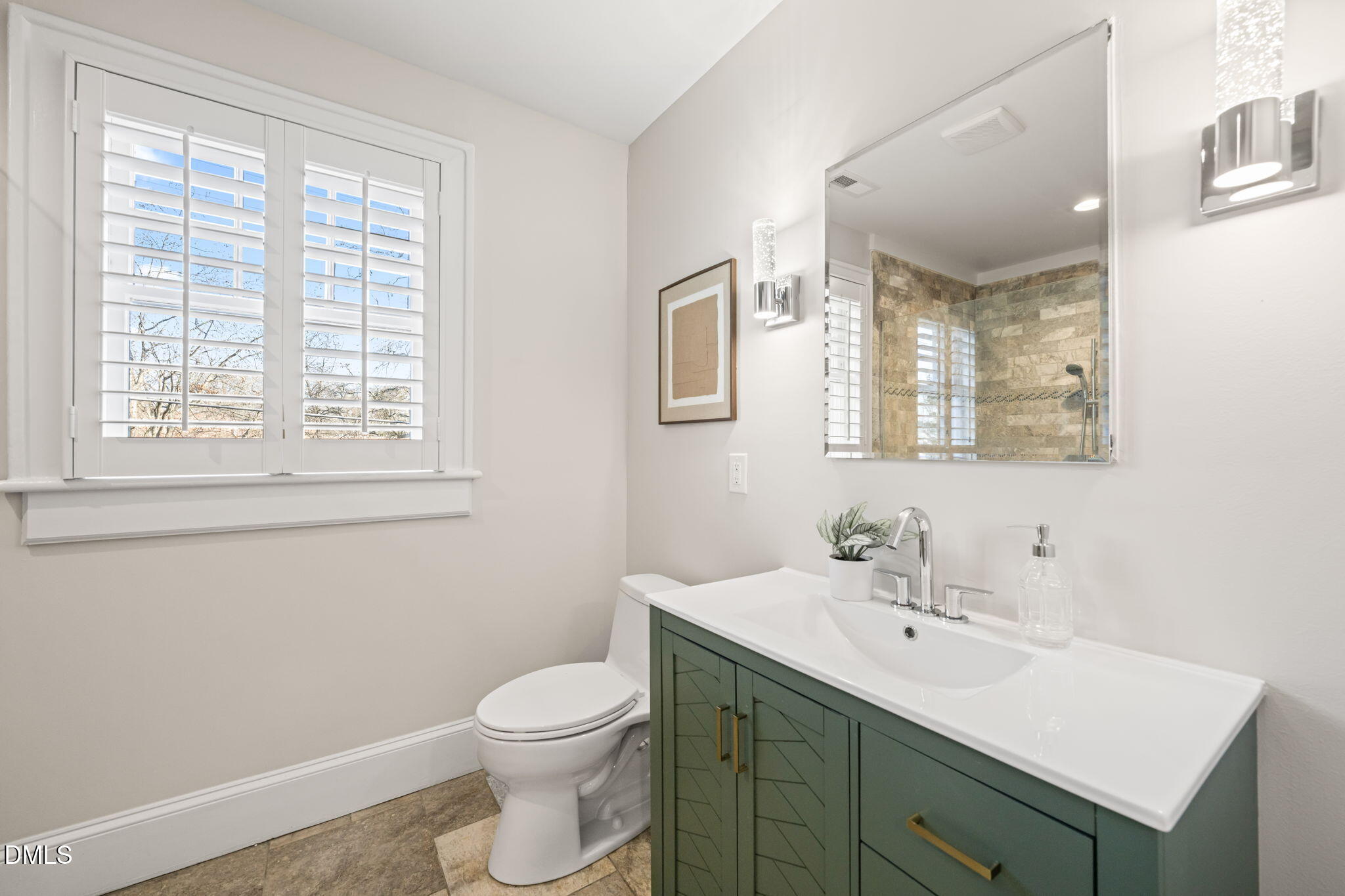 1617 Glenwood Avenue Raleigh, NC 27608 - Photo 37 of 58 a bathroom with a toilet a sink a mirror and a window