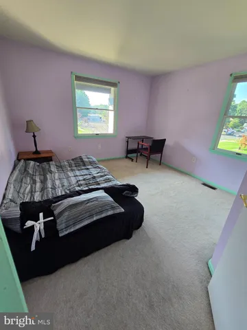 a bedroom with a bed dresser and a window