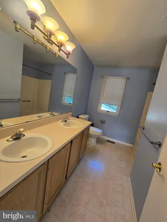 a spacious bathroom with a double vanity sink and a mirror