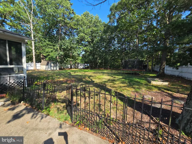 a view of a swimming pool with a patio and a yard