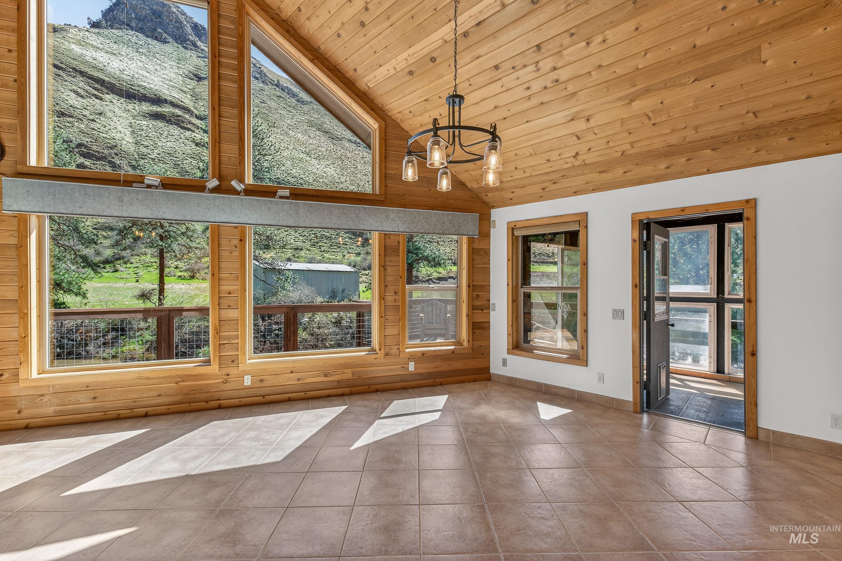 1352 South Main Street Riggins, ID 83549 - Photo 16 of 50 Unfurnished living room featuring a chandelier, tile patterned floors, and a vaulted wood ceiling