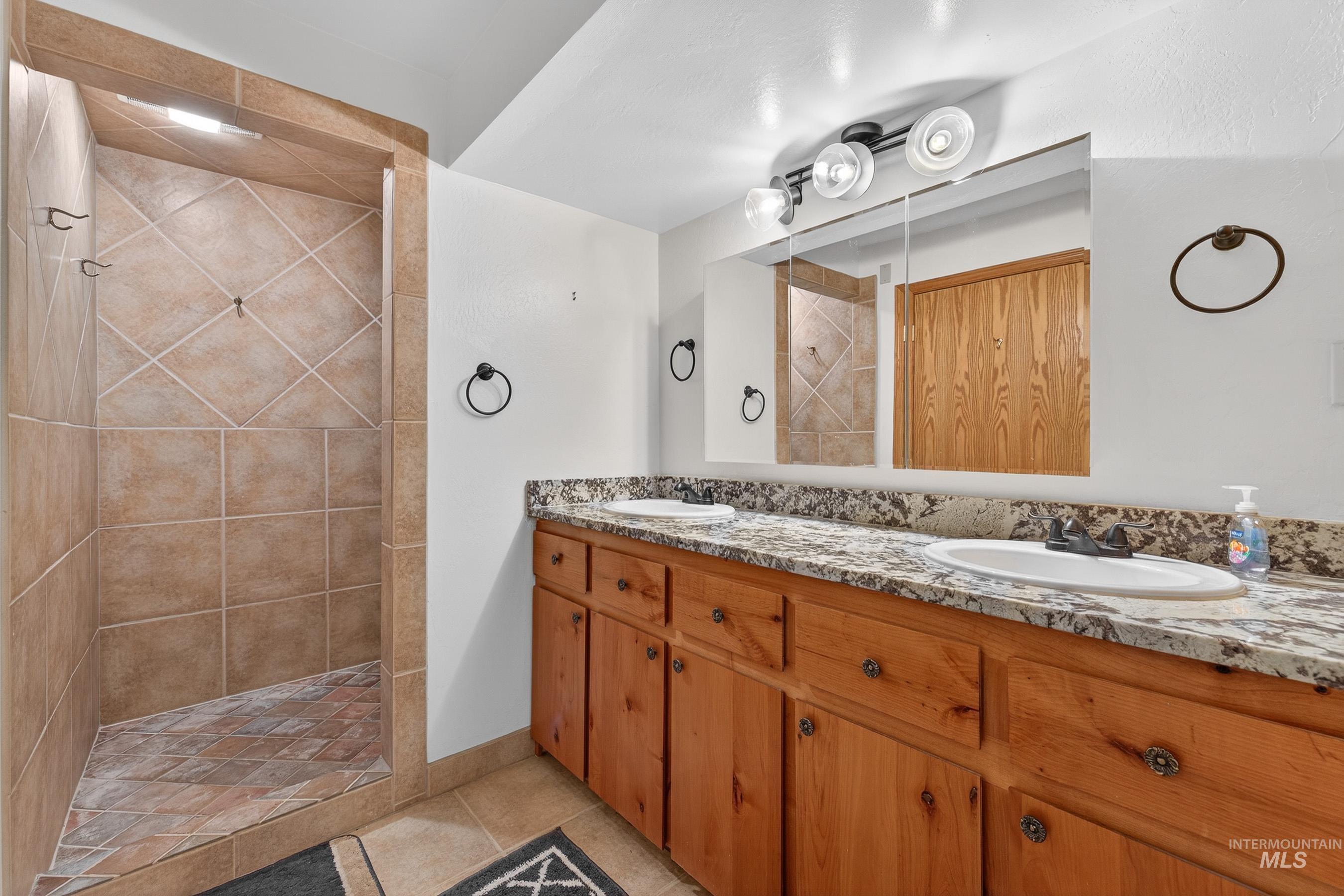 1352 South Main Street Riggins, ID 83549 - Photo 21 of 50 Full bathroom with double vanity, a tile shower, and light tile patterned floors