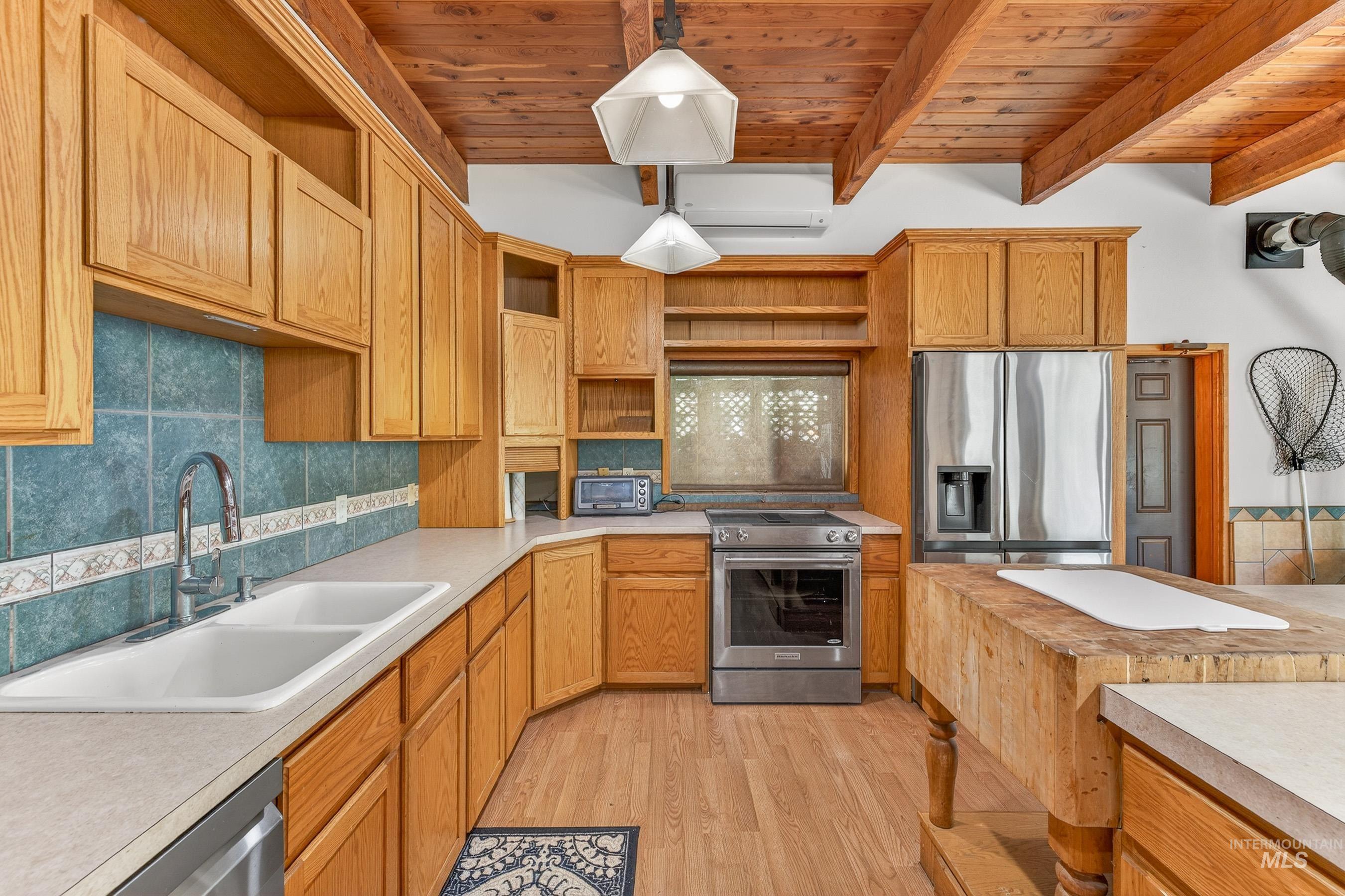 1352 South Main Street Riggins, ID 83549 - Photo 26 of 50 Kitchen featuring tasteful backsplash, open shelves, stainless steel appliances, light wood-style floors, and a wooden ceiling with exposed beams
