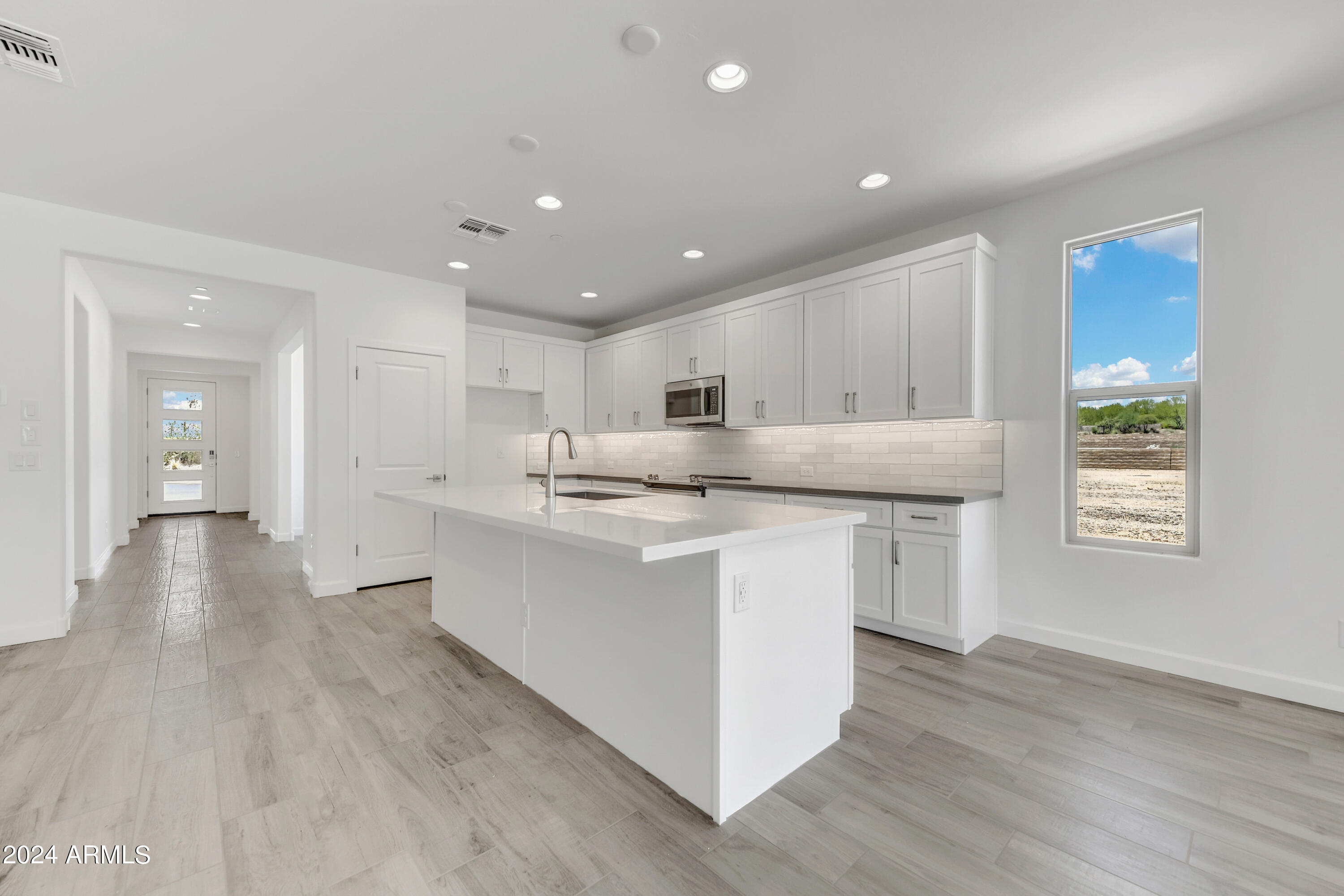 18238 East Coronado Cave Court Rio Verde, AZ 85263 - Photo 6 of 45 a kitchen with stainless steel appliances granite countertop a sink a stove a refrigerator and white cabinets with wooden floor