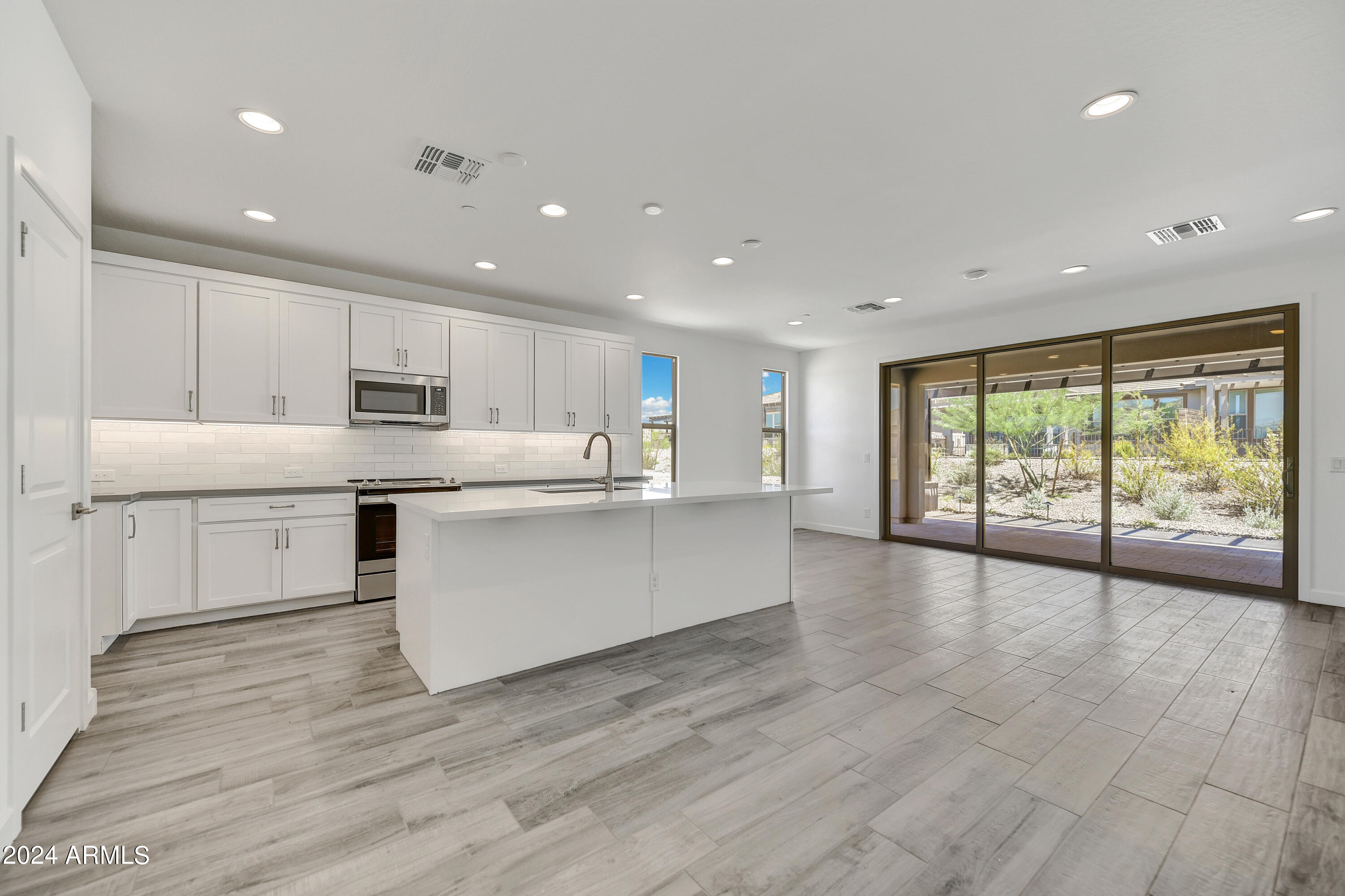 18238 East Coronado Cave Court Rio Verde, AZ 85263 - Photo 10 of 45 a large white kitchen with stainless steel appliances granite countertop a large counter top and a wooden floors