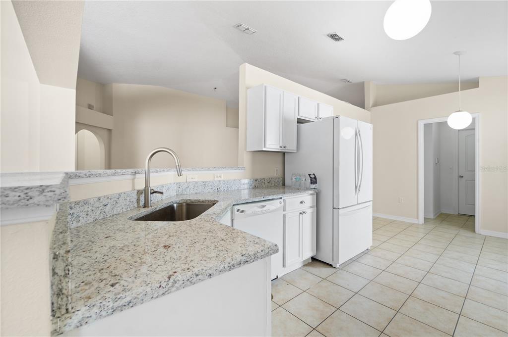 2339 Foxtree Road Tavares, FL 32778 - Photo 12 of 36 a kitchen with stainless steel appliances granite countertop a sink and a refrigerator