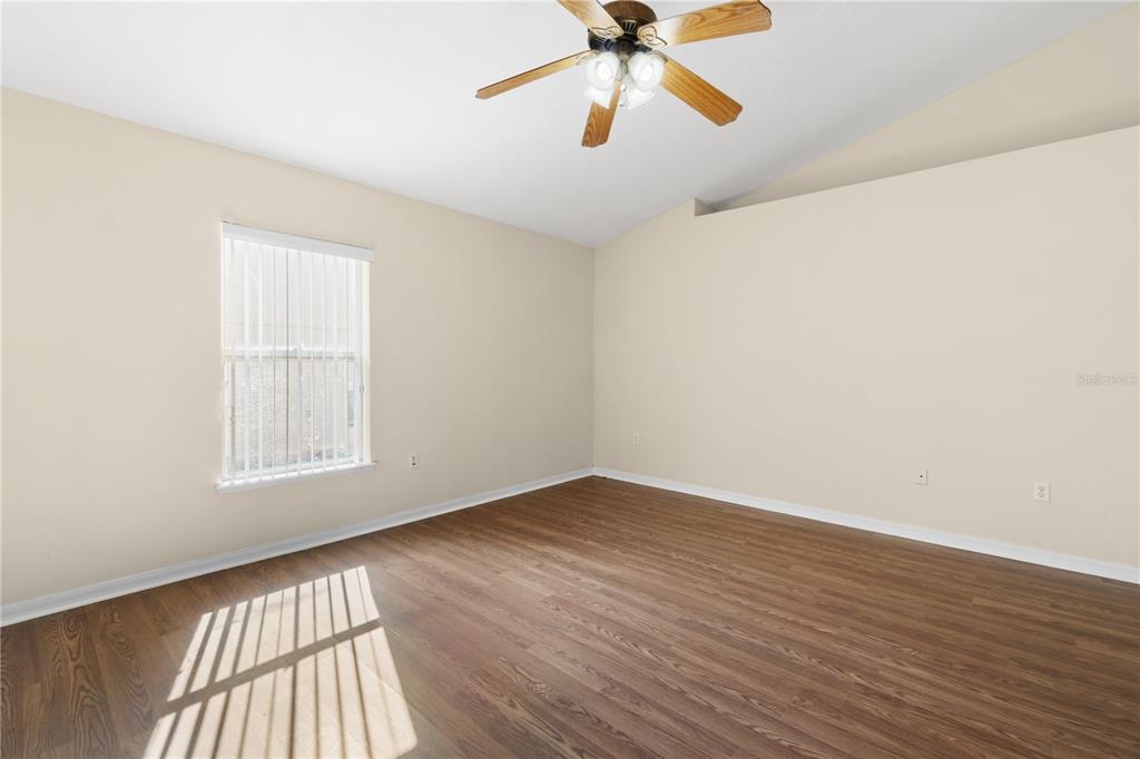 2339 Foxtree Road Tavares, FL 32778 - Photo 19 of 36 an empty room with wooden floor fan and windows