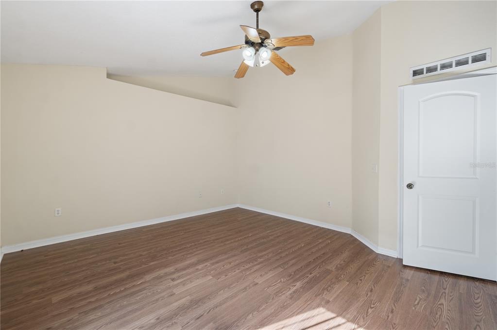 2339 Foxtree Road Tavares, FL 32778 - Photo 20 of 36 an empty room with wooden floor ceiling fan and window