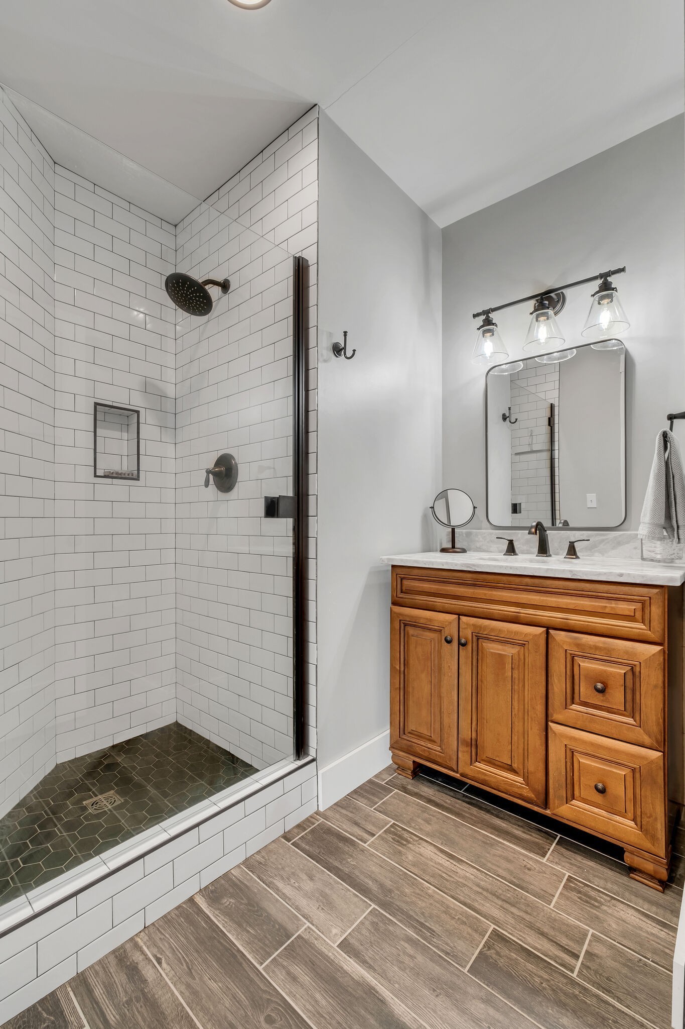 7890 Oscar Green Road Primm Springs, TN 38476 - Photo 34 of 52 a bathroom with a granite countertop sink a mirror and shower