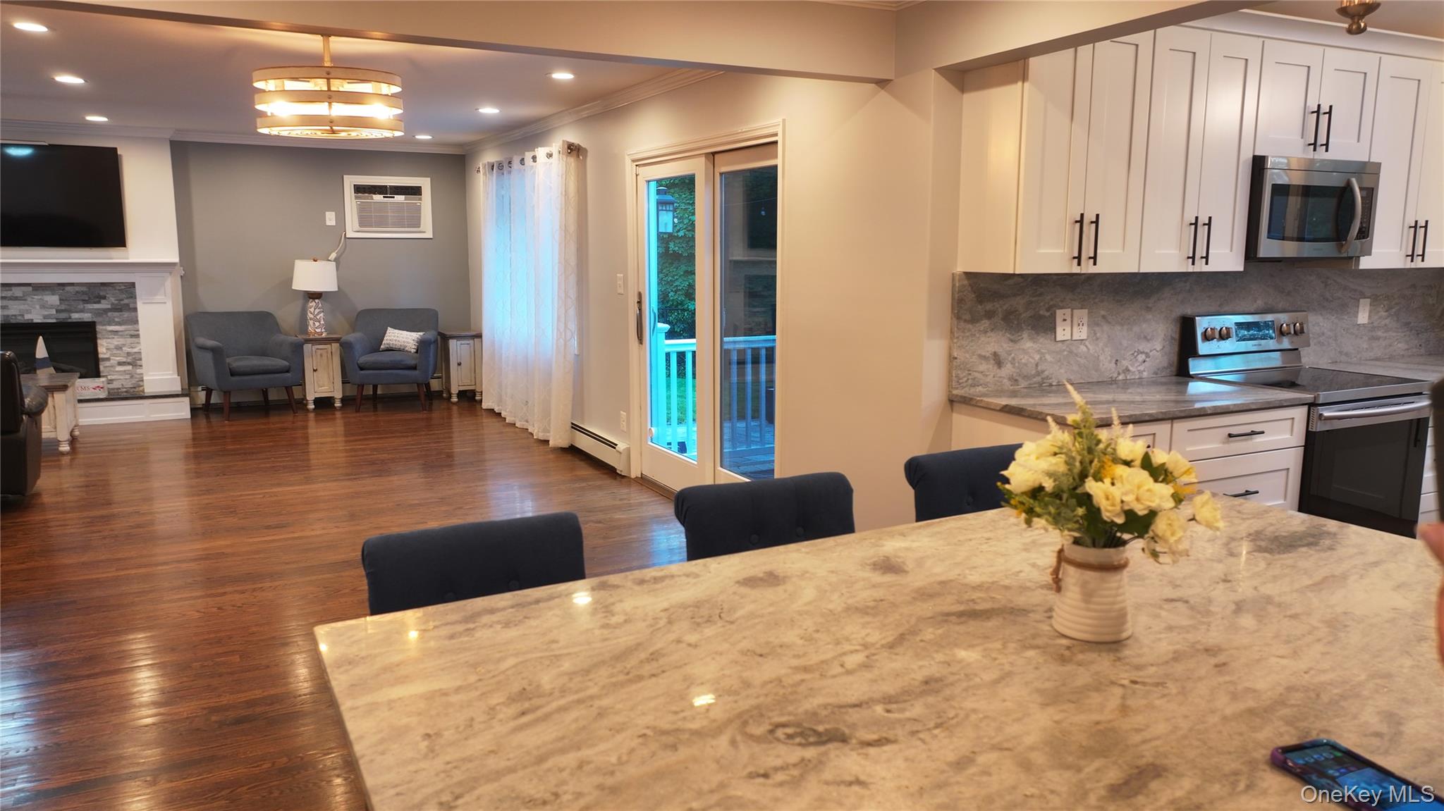522 Moriches Road St. James, NY 11780 - Photo 12 of 49 a kitchen with stainless steel appliances kitchen island granite countertop a table chairs in it and a microwave