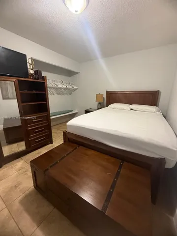 a bedroom with a bed and a television