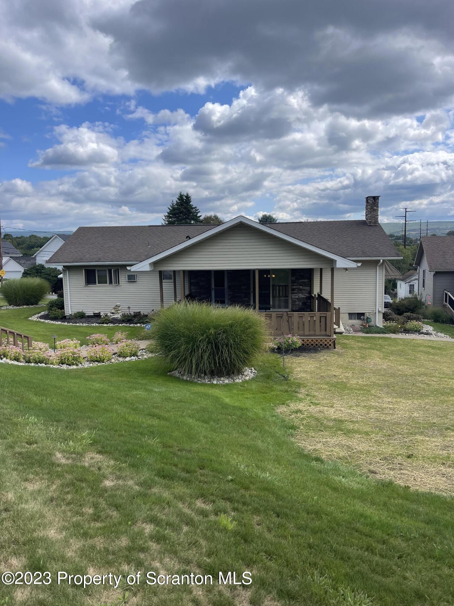 225 Main Street Olyphant, PA 18447 - Photo 18 of 60 a view of a house with a big yard and potted plants