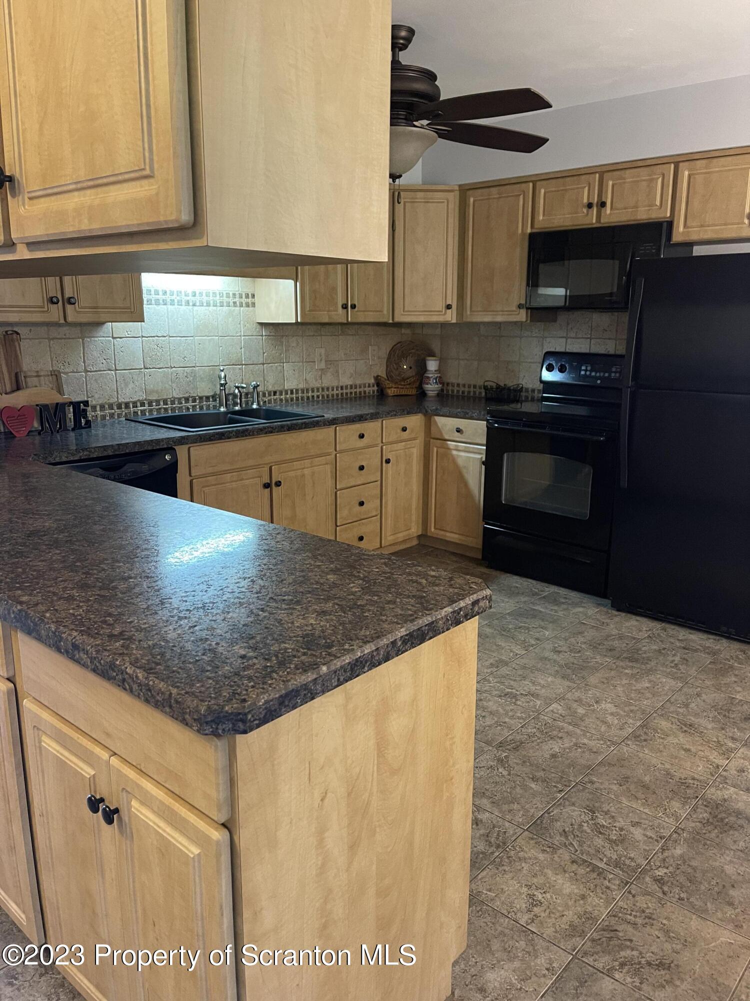 225 Main Street Olyphant, PA 18447 - Photo 20 of 60 a kitchen with granite countertop a sink a stove and cabinets